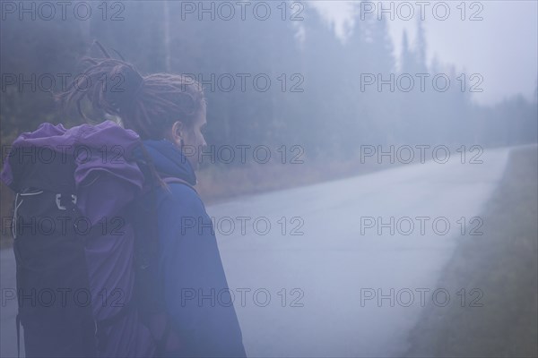Caucasian hiker walking on remote road