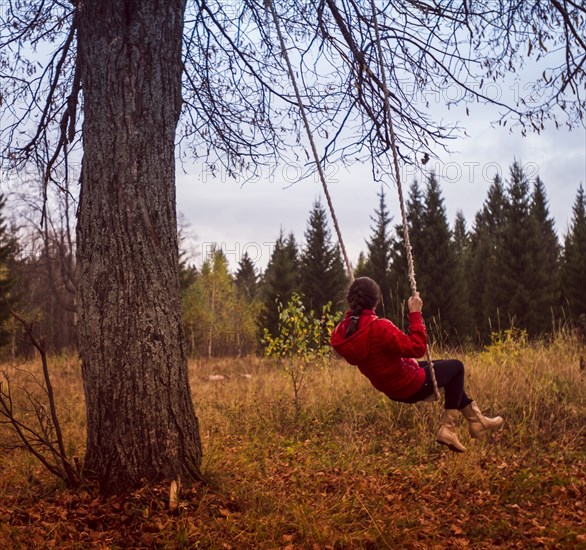 Caucasian girl playing on swing