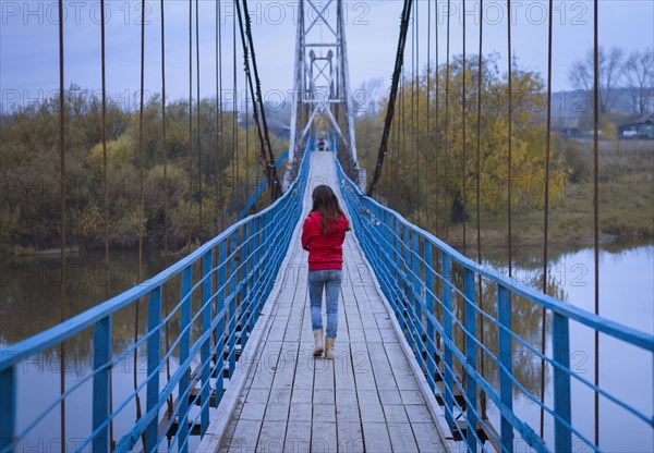 Caucasian girl walking on bridge