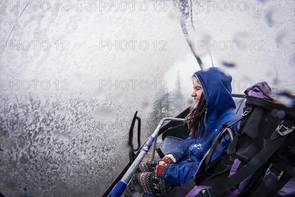 Caucasian hiker riding ski lift