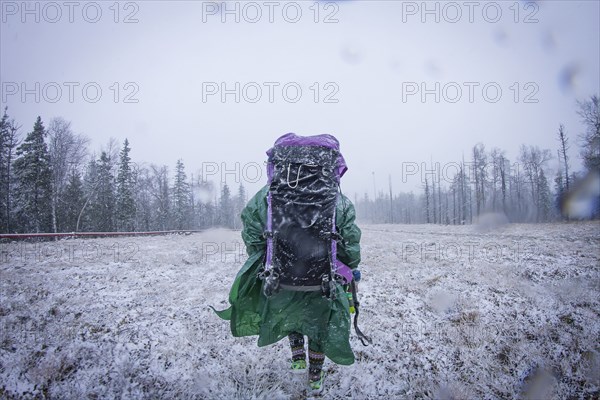 Caucasian hiker standing in frosty field
