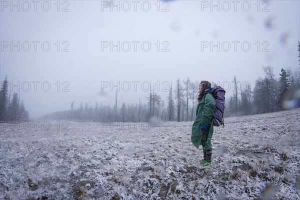 Caucasian hiker standing in frosty field