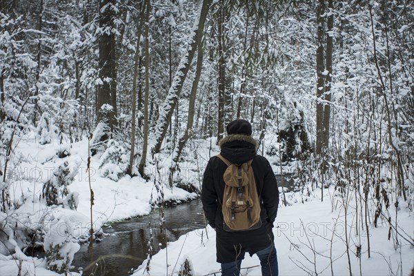 Caucasian hiker walking in snowy forest