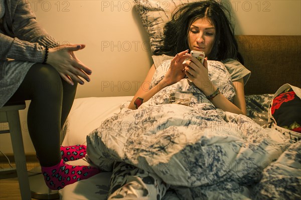 Caucasian woman using cell phone on bed