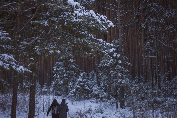 Caucasian women walking in snowy forest