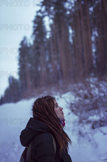 Caucasian woman standing in snowy forest