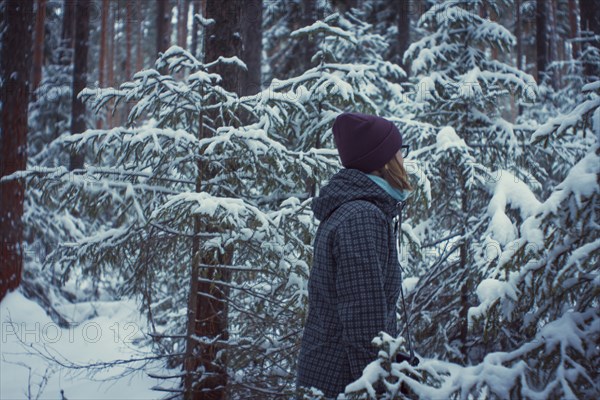 Caucasian woman standing in snowy forest