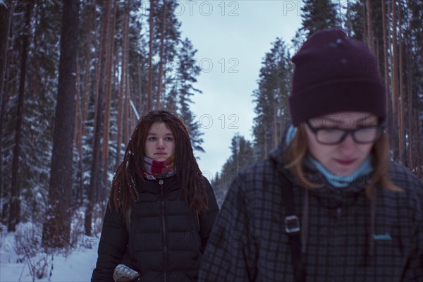 Caucasian women walking in snowy forest