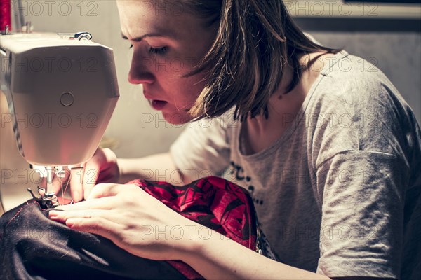 Caucasian woman using sewing machine