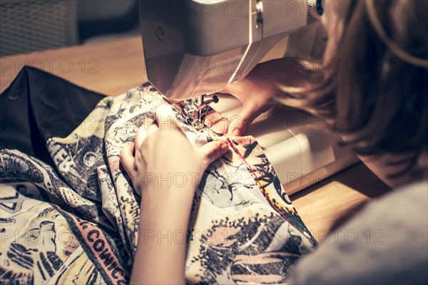 Caucasian woman using sewing machine