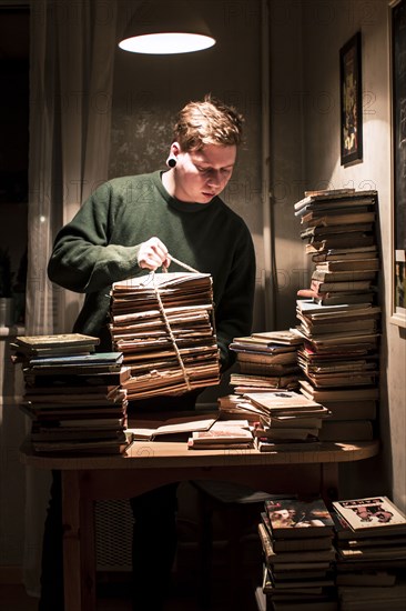 Caucasian man holding stack of books