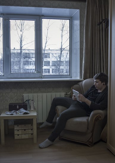 Caucasian man reading digital tablet in living room