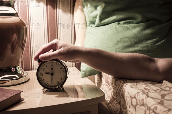 Caucasian man turning off alarm clock