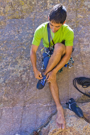 Hispanic man preparing for rock climbing