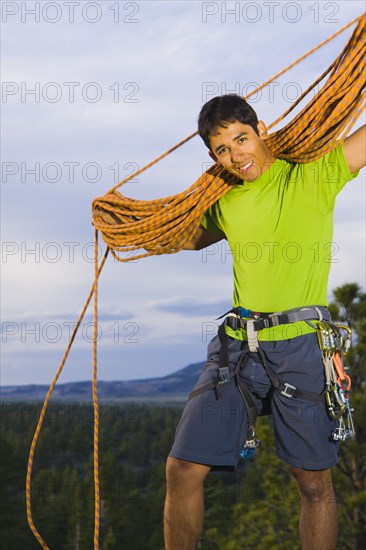 Hispanic man preparing for rock climbing