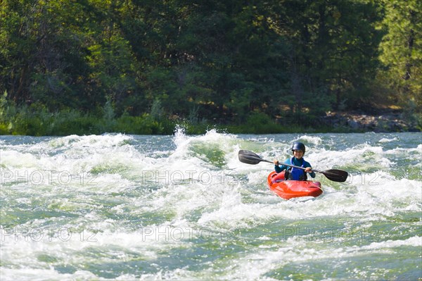 Caucasian girl kayaking in river