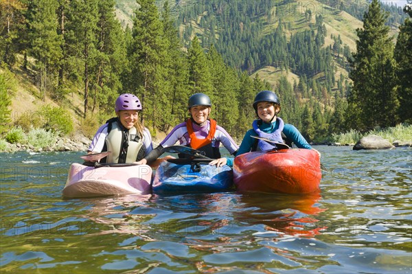 Caucasian girls kayaking in river