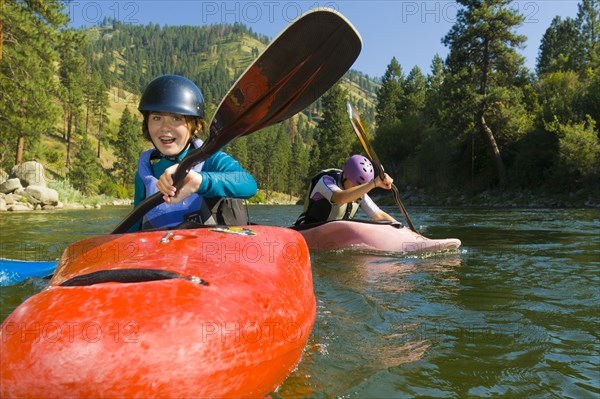 Caucasian girls kayaking in river