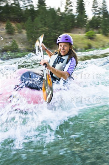 Caucasian teenager kayaking in river