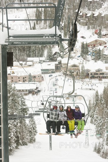 Friends riding ski lift
