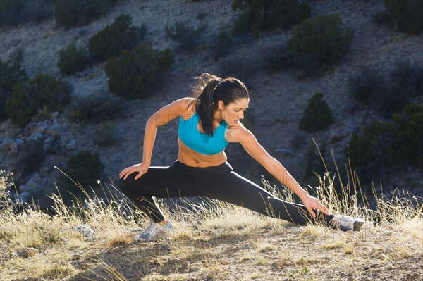 Hispanic woman stretching before exercise