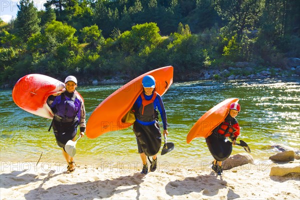 Caucasian family carrying kayaks