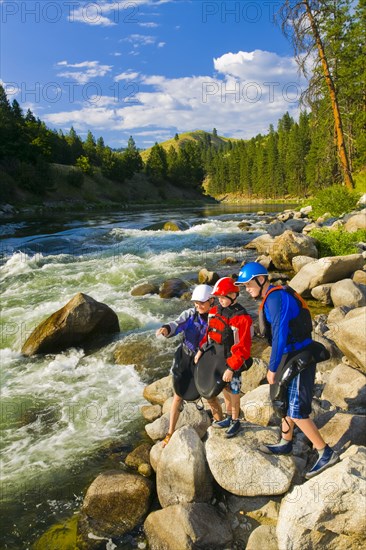 Caucasian family standing on rocks near river