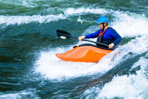 Caucasian boy kayaking on river