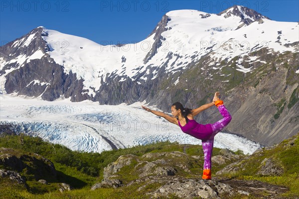 Korean woman practicing yoga with mountain in background