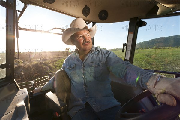 Hispanic man driving tractor