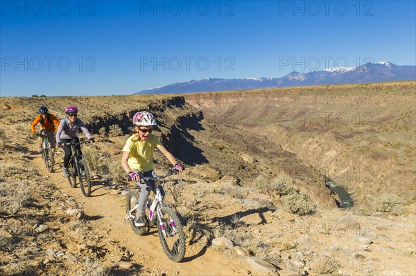 Family mountain biking near canyon