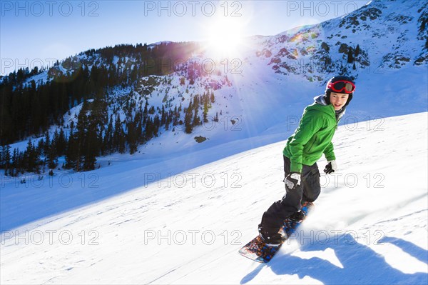 Mixed race teenager snowboarding