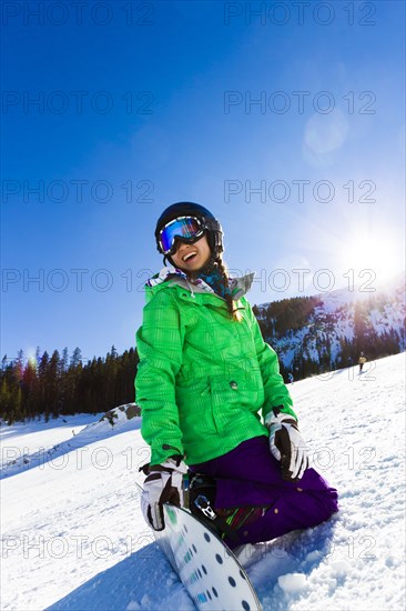 Mixed race teenager snowboarding