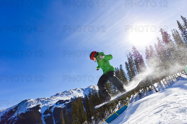 Mixed race teenager snowboarding