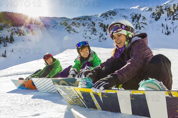 Teenagers snowboarding together