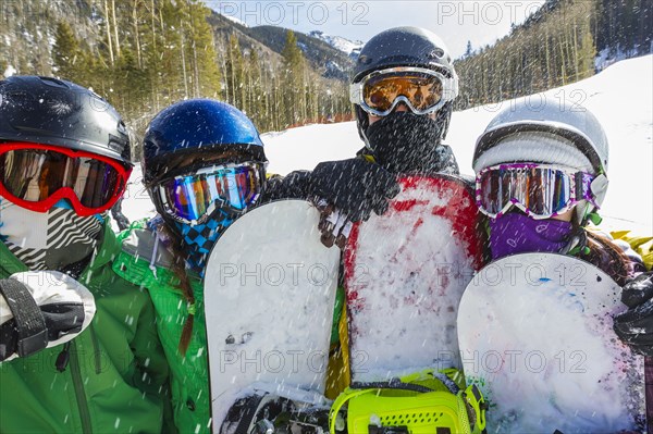 Teenagers snowboarding together