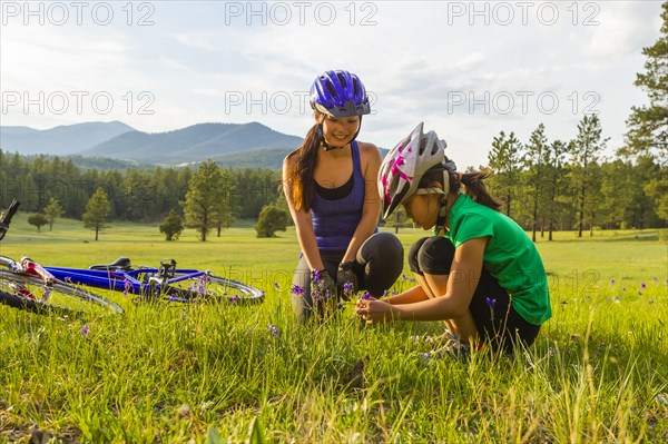 Mother and daughter sitting in meadow