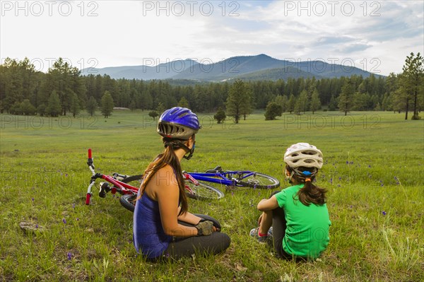 Mother and daughter sitting in meadow