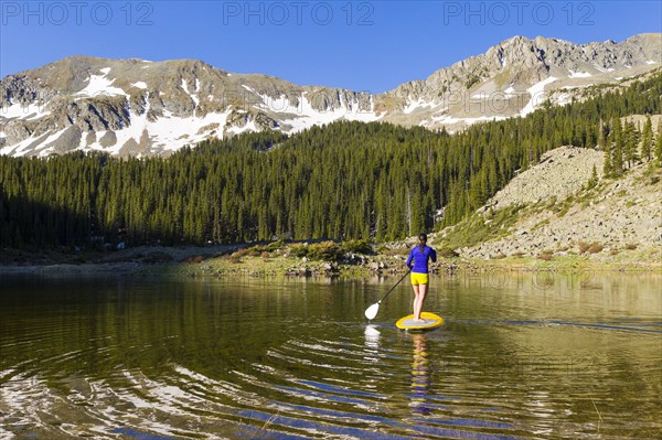 Hispanic woman riding paddle board