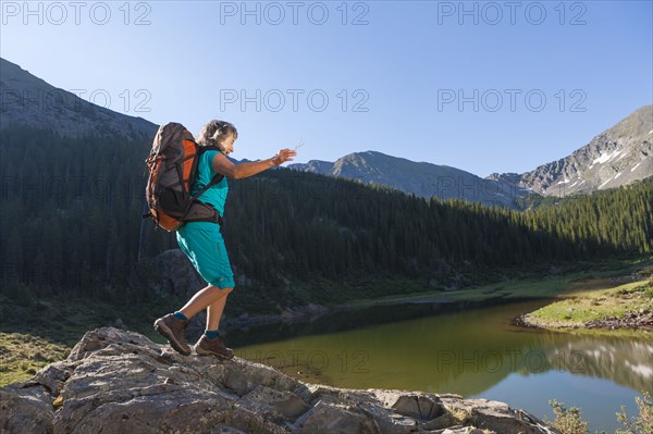 Hispanic woman hiking on boulder