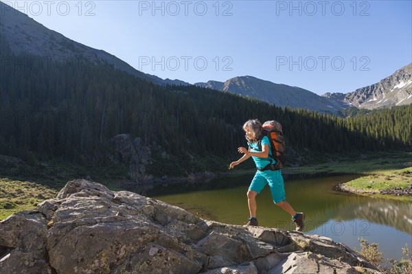 Hispanic woman hiking on boulder