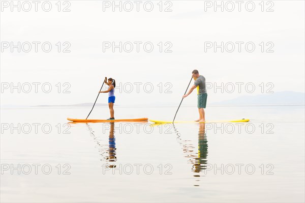 Couple riding paddle boards