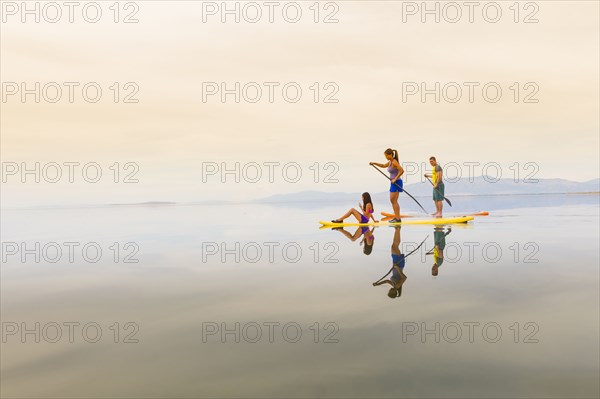 Family riding paddle boards