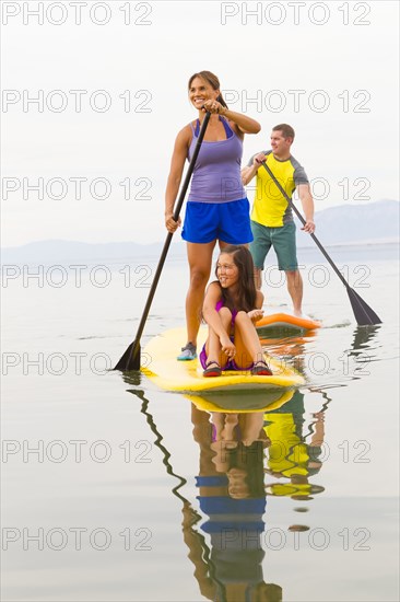 Family riding paddle boards