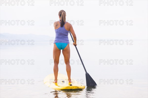 Filipino woman riding paddle board