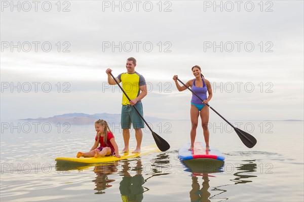 Family riding paddle boards