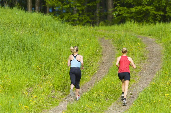 Caucasian women running on path