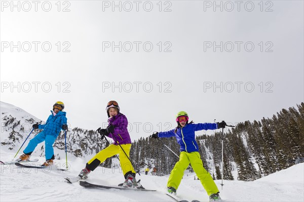 Girls skiing together on snowy slope