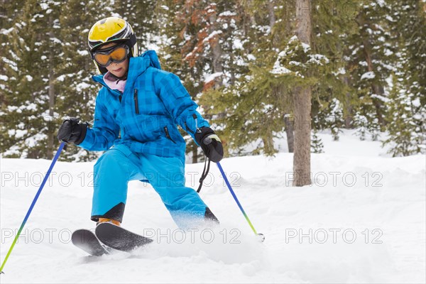 Mixed race girl skiing on snowy slope