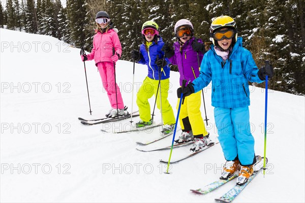 Children skiing together on snowy slope